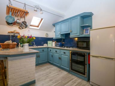 A kitchen with cabinets, stove, refrigerator, and a sink at Hafod Y Felinheli