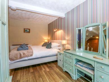A bedroom with a bed and dressing table at Hafod in Y Felinheli