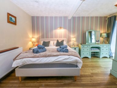 A bedroom with a bed and dressing table at Hafod Y Felinheli