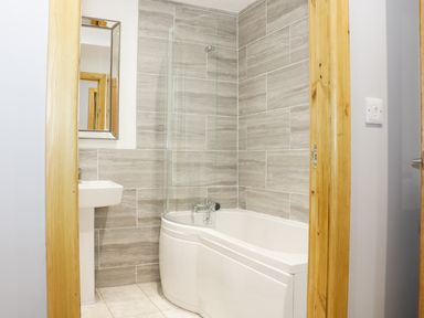 A bathroom with a bathtub shower sink and mirror at Gardeners Lodge in Nantwich