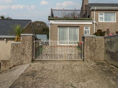 An outdoor area with a gate and a house front at Maesawel Studio in Llanfair