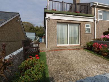 A garden with a bench and flowers at Maesawel Studio in Llanfair