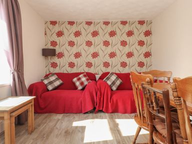 A living room with a sofa and dining table at The Farmhouse in Brynsiencyn near Newborough