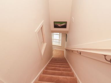 A staircase with a handrail and a window at Kelsick Heights in Ambleside