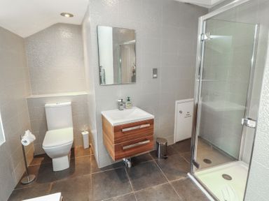 A bathroom with a toilet, sink, and shower at Kelsick Heights in Ambleside