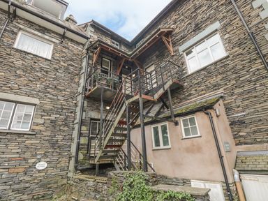 A metal staircase and balcony attached to stone and plaster exterior walls of a building at Loughrigg View in Ambleside