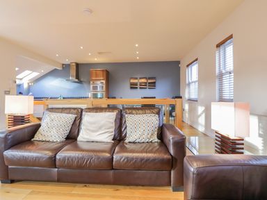 A living room with brown leather sofas and two table lamps behind the sofa at Wrenville in Keswick