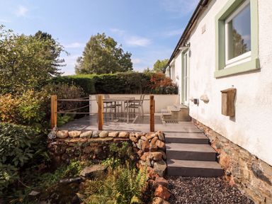 An outdoor patio with a table and chairs at Mell View Cottage in Ullswater