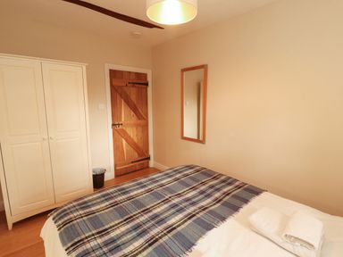 A bedroom with a bed and wardrobe at Mell View Cottage Ullswater