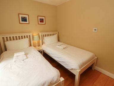 A bedroom with two beds and a bedside table at Mell View Cottage in Ullswater