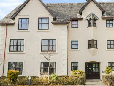 Exterior of a multi windowed residential building with shrubs and small trees at Andra Ghyll in Keswick