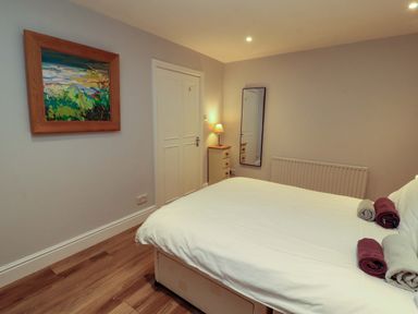 A bedroom with a bed and a dresser at Archers in Keswick