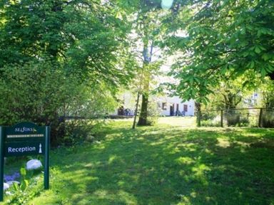 A grassy area with trees and a reception sign near a white building at Whitbarrow Holiday Village Troutbeck 5 Ullswater