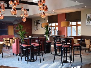 A dining area with tall tables and chairs pendant lights and windows at Whitbarrow Holiday Village Troutbeck 5 Ullswater