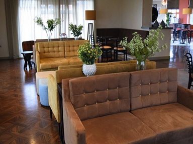 A living room with multiple sofas tables and flower vases at Whitbarrow Holiday Village Troutbeck 5 Ullswater