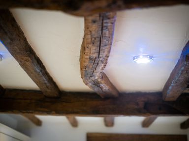 A ceiling with exposed wooden beams and recessed lights at Grayrigg Foot Stable in Grayrigg