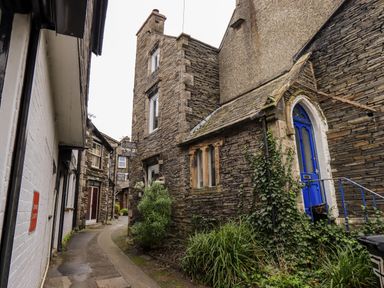 A narrow alley with stone buildings and a bright blue door at Granary Nook in Windermere