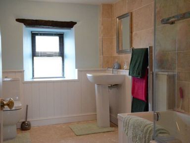 A bathroom with a toilet sink bathtub towels and a window at Greety Gate House in Foxfield