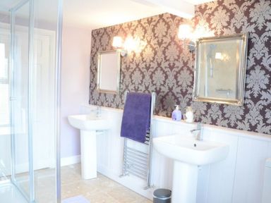 A bathroom with two sinks mirrors and a shower at Greety Gate House in Foxfield
