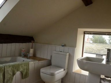 A bathroom with a bathtub towel toilet and sink near a window at Greety Gate House in Foxfield