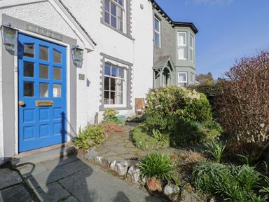 The front entrance of a house with a blue door and surrounding garden at White House in Keswick