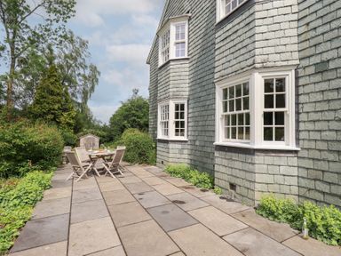 An outdoor patio area with a table and chairs at Little Ellers in Portinscale near Keswick
