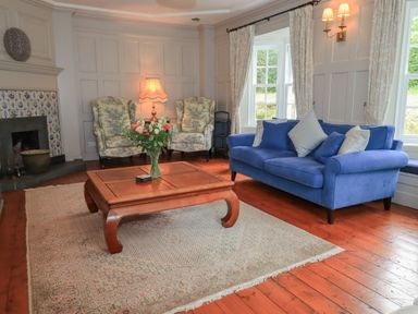 A living room with armchairs, a sofa, and a coffee table at Little Ellers Portinscale near Keswick