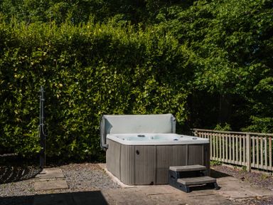 A hot tub with steps in a garden at The Snug Longtown