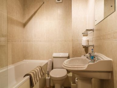 A bathroom with a bathtub a toilet and a pedestal sink at Siskin in Keswick
