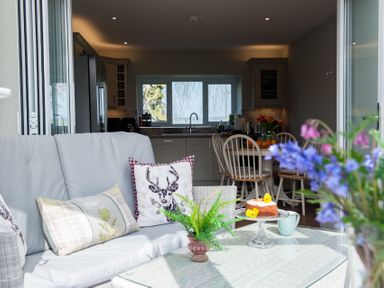 A kitchen and dining area with a sofa and cushions in the foreground at Westmains Farm in Penton