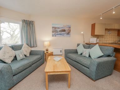 A living room with two sofas and a wooden coffee table at Treetops in Windermere