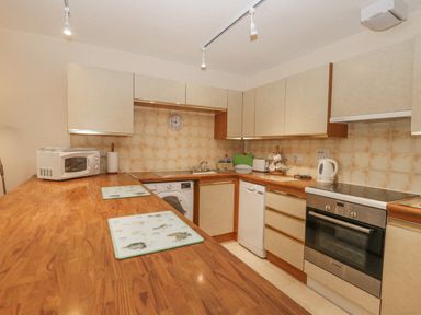 A kitchen with wooden countertops appliances and beige cabinets at Treetops in Windermere