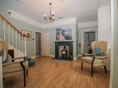 A sitting room with two armchairs and a fireplace at The Old Vicarage in Keswick