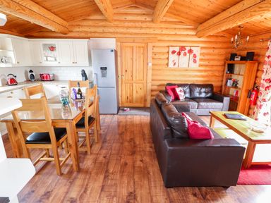 An open plan kitchen and living room with wooden furniture and floors at Church View in Greetham Rutland
