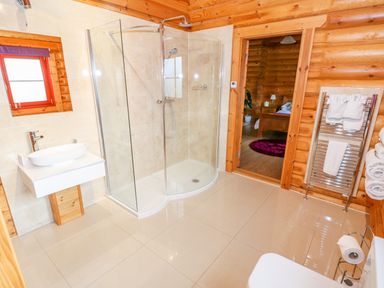 A bathroom with a shower cabin sink towel rack and toilet at Beech Lodge in Greetham Rutland