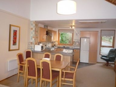 A kitchen and dining area with a wooden dining table and chairs at 20 Keswick Bridge in Keswick