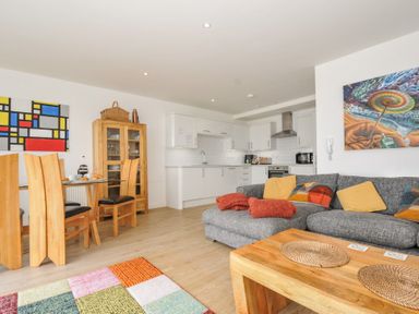 A living room with sofa and dining area at The View in Newquay