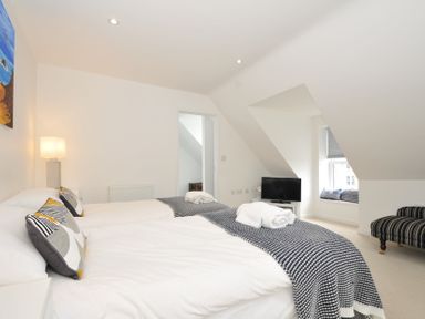 A bedroom with two beds and a television at The View in Newquay