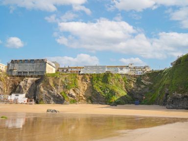 A beach with cliffs and buildings in the background at The View in Newquay