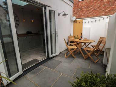 An outdoor patio with a table and chairs at Harriet's Cottage in Briggswath