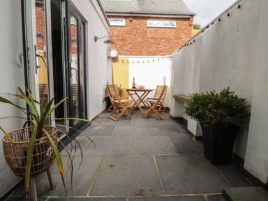 An outdoor space with a table and chairs at Harriet's Cottage in Briggswath