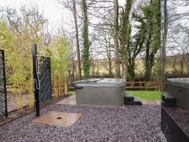 An outdoor area with a hot tub shower and trees at Reflection in Longtown