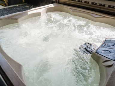 A hot tub filled with water in an outdoor area at Reflection in Longtown