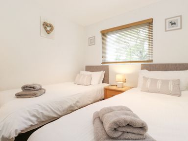 A bedroom with two single beds bedside table and lamp at 10 Thirlmere White Cross Bay near Troutbeck Bridge