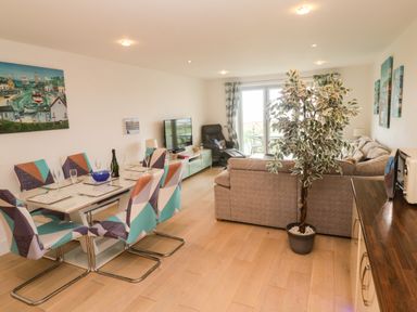 A living room with a dining area and sofa at Ocean Seven in Newquay