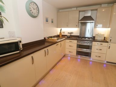 A kitchen with cabinets and appliances at Ocean Seven in Newquay