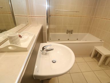 A bathroom with a sink and bath tub at Ocean Seven in Newquay