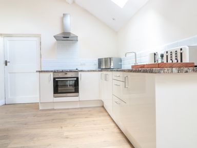 A kitchen with a stove oven range hood microwave toaster and kettle on a countertop at Granary 2 in Madley