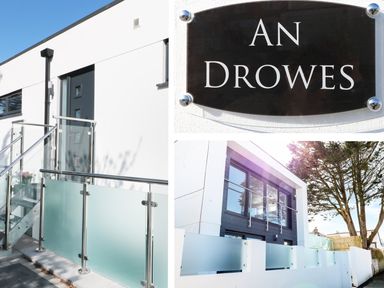 The exterior of a modern building with glass and metal railings and a sign that reads An Drowes in Newquay