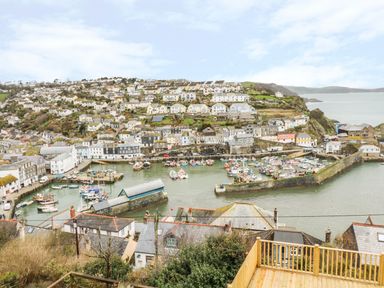 A view of a harbor with boats docked and houses on a hillside at Pink House in Mevagissey